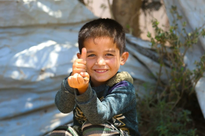 A young boy holding a hot dog in his hand